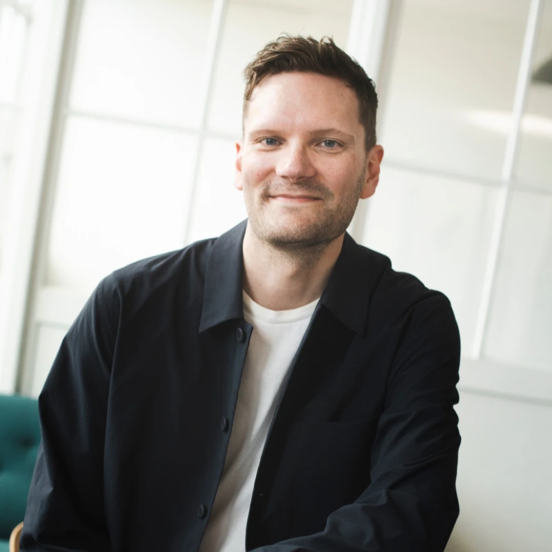 Michael Liepke Kruse smiler, mens han sidder på et bord.